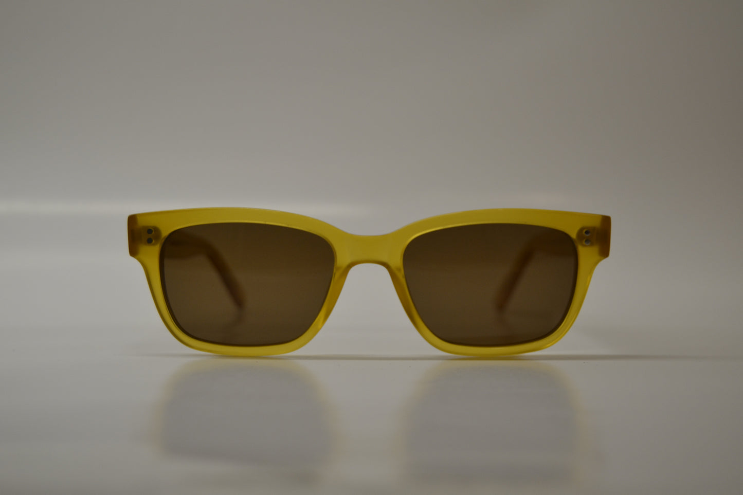 A pair of yellow-framed sunglasses with polarized lenses, displayed against a neutral background.