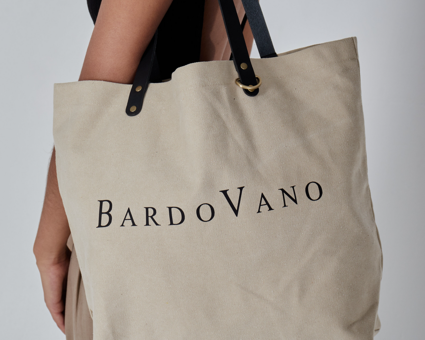 Beige tote bag with 'BardoVano' branding held by a person against a neutral background