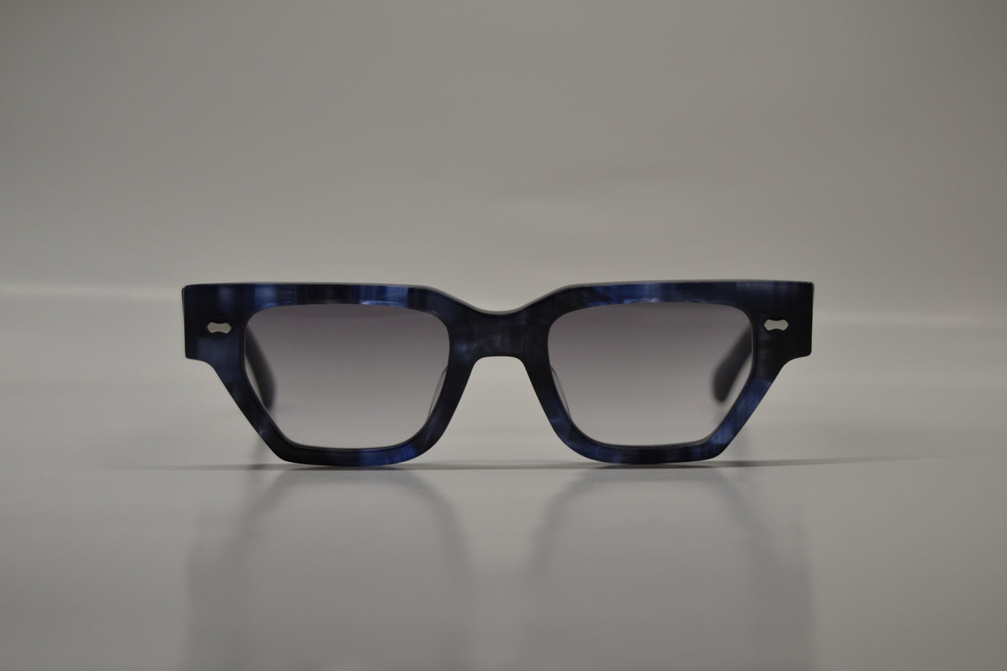 A pair of limited edition sunglasses with a blue acetate frame, polarized lenses, and UV protection.