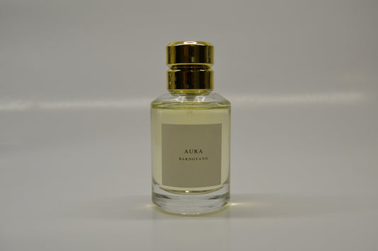 Perfume bottle labeled 'Aura' with a gold cap on a gray background