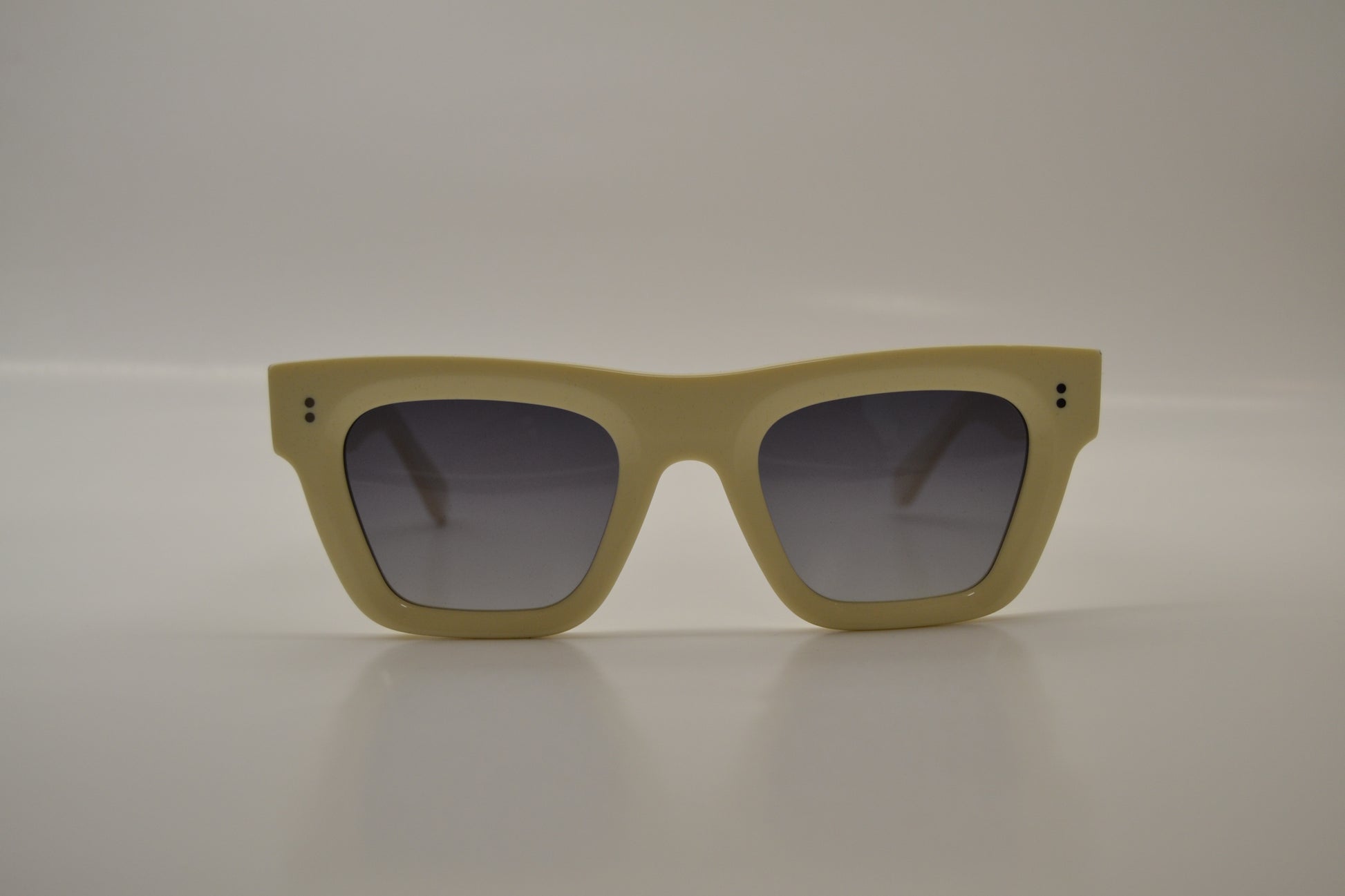 A pair of beige framed sunglasses with polarized lenses.