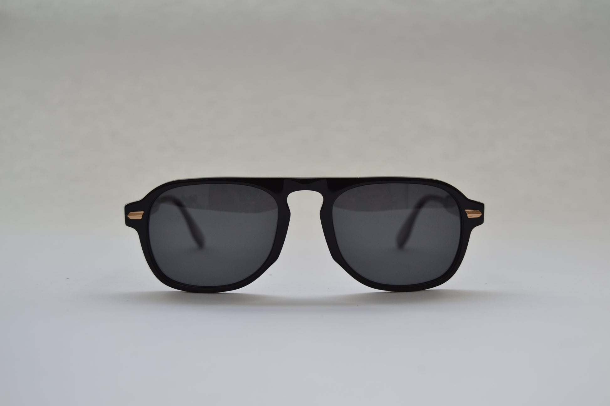 A pair of sunglasses with a polarized lens and UV400 protection, handcrafted from premium materials, displayed against a neutral background.