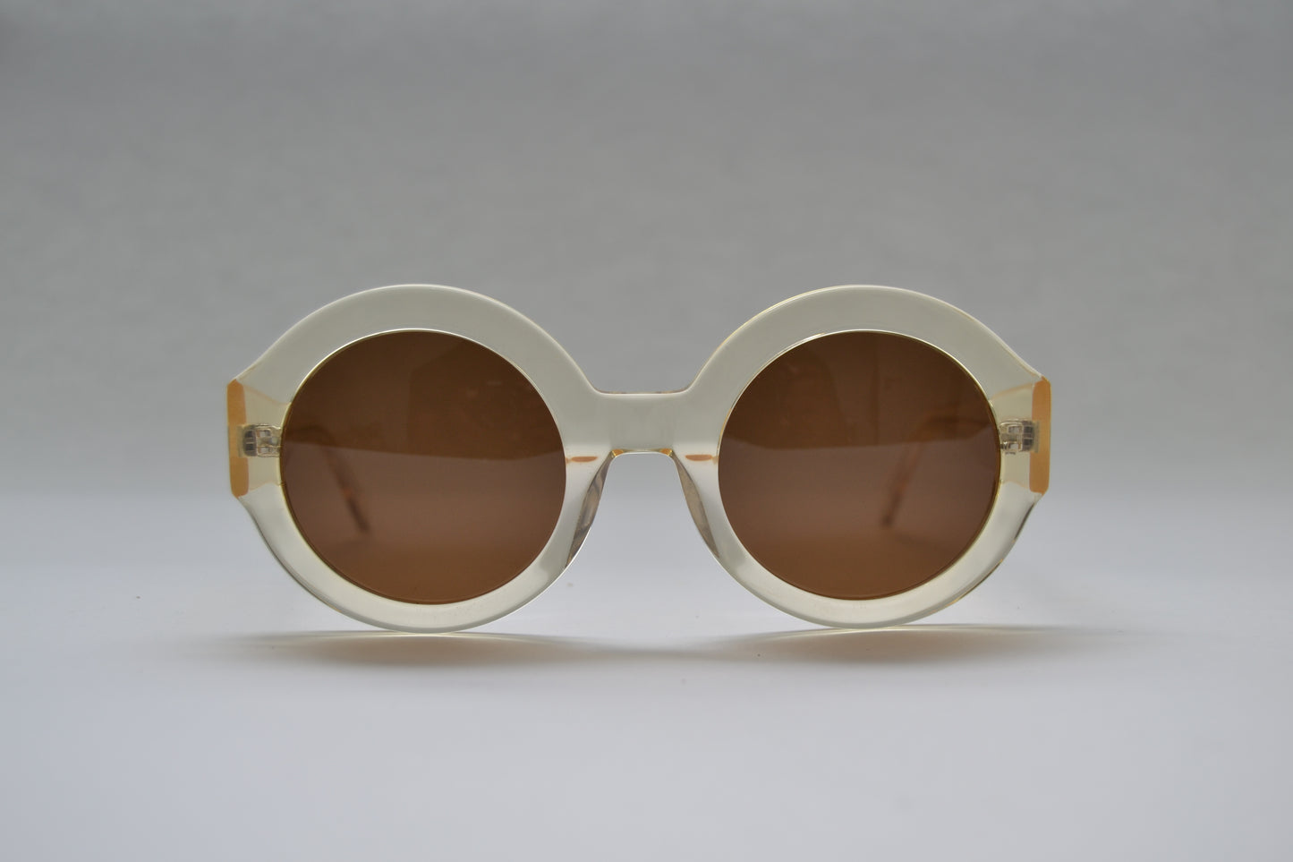 A pair of black, round-framed sunglasses with polarized lenses on a light background.