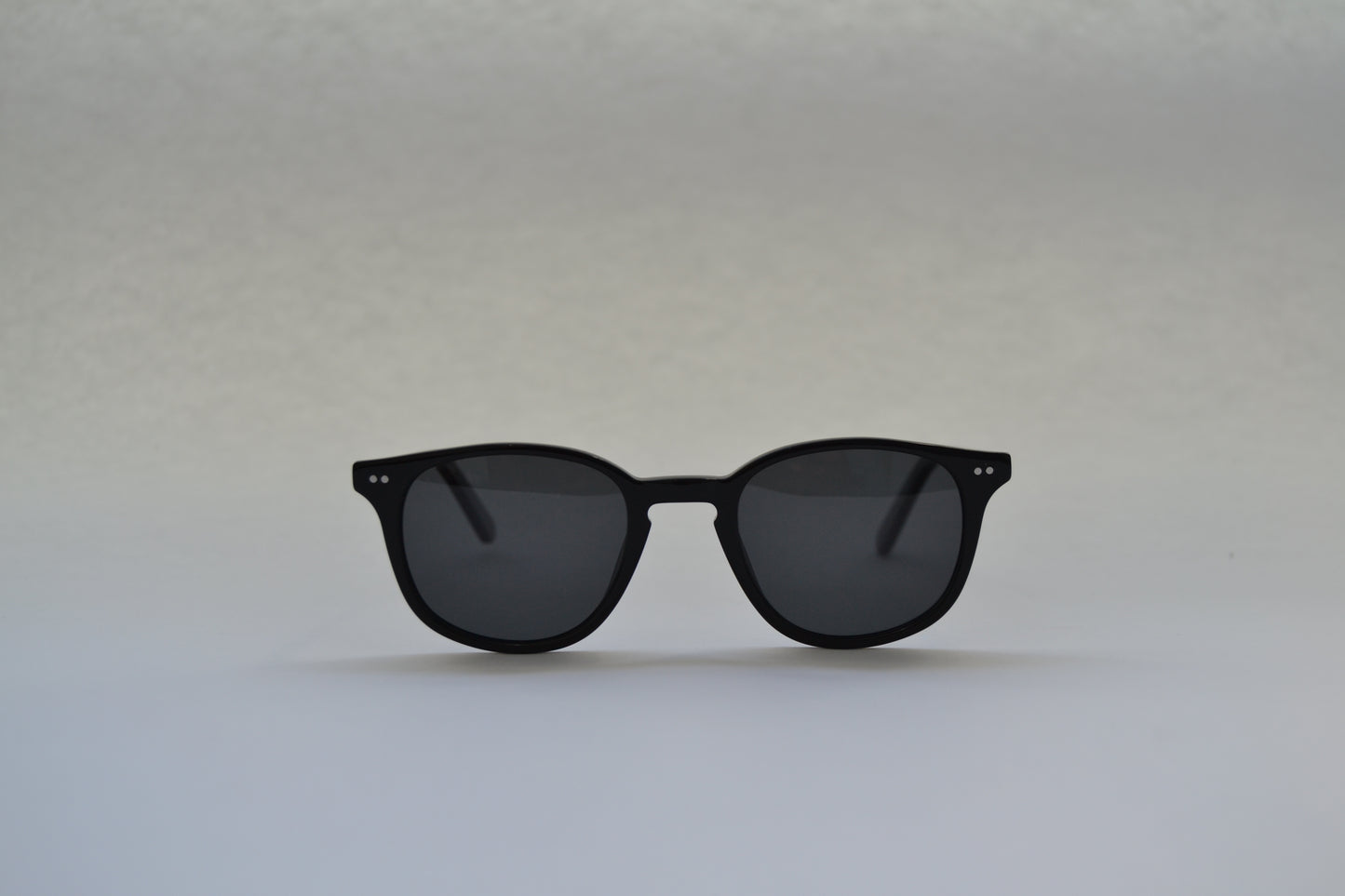 A pair of sunglasses with a black frame and patterned with a tortoiseshell design, featuring polarized lenses.
