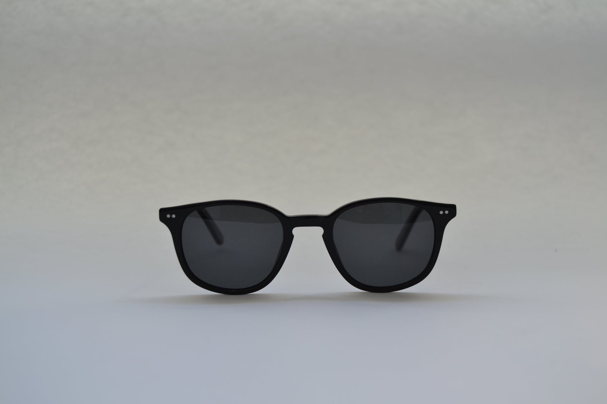 A pair of sunglasses with a black frame and patterned with a tortoiseshell design, featuring polarized lenses.